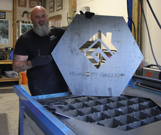 image of shawn lloyd with octagonal metal sign for homes by gallion